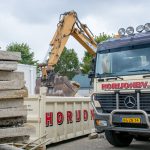 Horijon laadt puin in containervrachtwagen om puin af te voeren